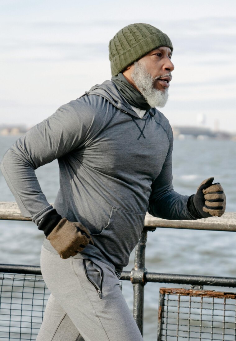 A distinguished older man running along the water